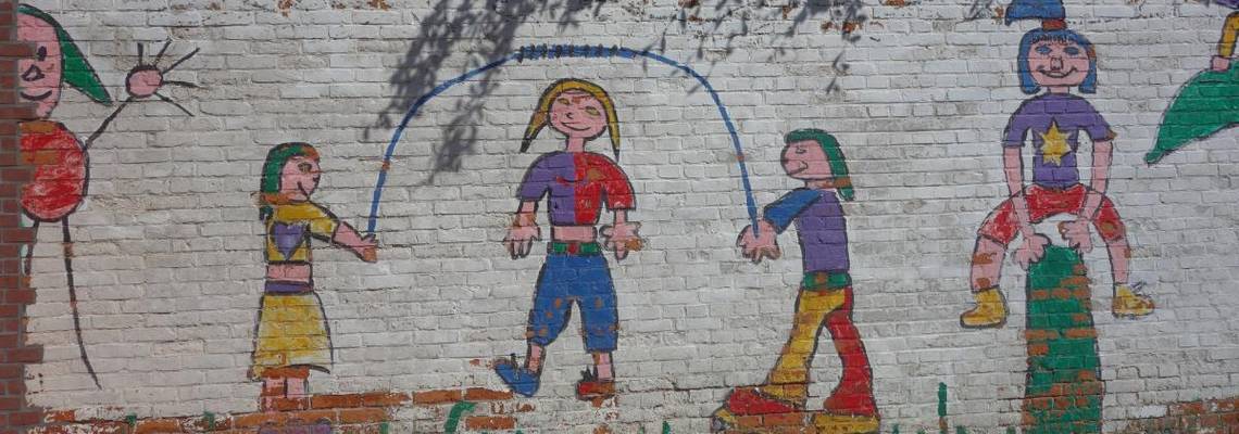 Eine Mauer ist mit Seil springenden Kinder bemalt