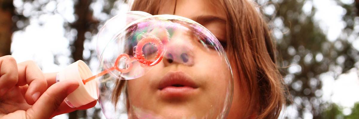 Kind pustet eine Seifenblase