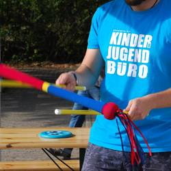 Mitarbeiter im Kinder- und Jugendbüro T-Shirt spielt mit dem Devil Stick
