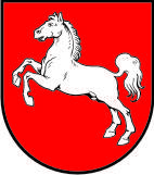 Ein Wappen mit rotem Hintergrund und einem weißen Pferd mit erhobenen Vorderhufen