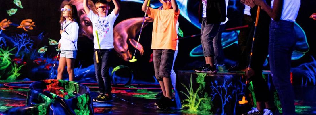 Kinder im Schwarzlicht beim Neongolf