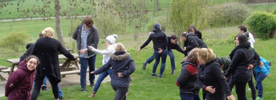 Jugendliche auf der Wiese beim Gruppenspiel