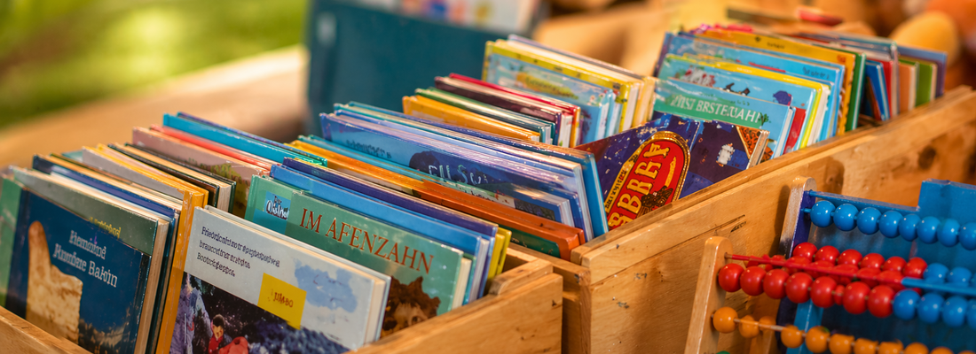 verschiedene Bücherkisten, ein Abakus lehnt davor