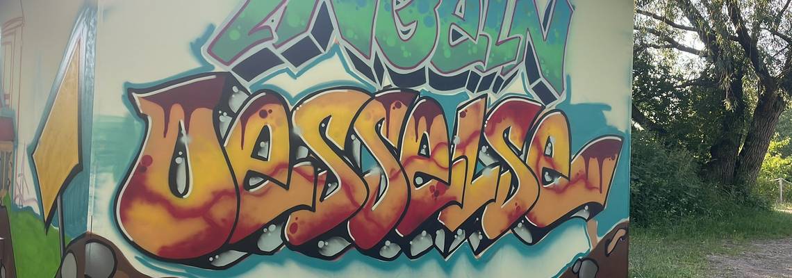Die neu gestaltete Rückwand des Jugendplatzes in Ingeln-Oesselse mit dem Namen des Dorfes als Graffiti-Schrifzug