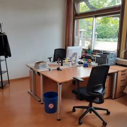 Das Büro mit zwei Schreibtischen und einer Garderobe