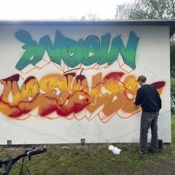 Der Schriftzug "Ingeln-Oesselse" wird von einem Jugendlichen bearbeitet