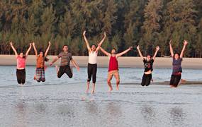 Eine Gruppe von Jugendlichen, die in einem Fluss in die Luft springen.