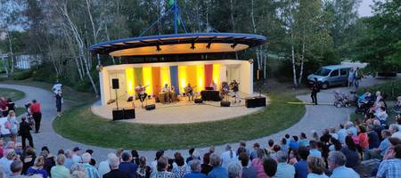 Blick von der vollbesetzten Tribüne der Kulturbühne im Park der Sinne  auf ein Konzert