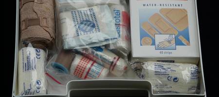 Ein geöffneter Erste-Hilfe-Koffer mit Pflastern und Verbänden