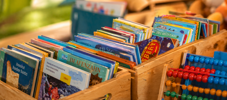 verschiedene Bücherkisten, ein Abakus lehnt davor